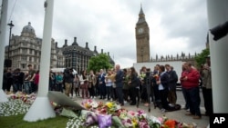 Staff from Britain's opposition Labour Party stand together before placing floral tributes for their colleague Jo Cox, the 41-year-old British Member of Parliament shot to death yesterday in northern England, on Parliament Square outside the House of Parl