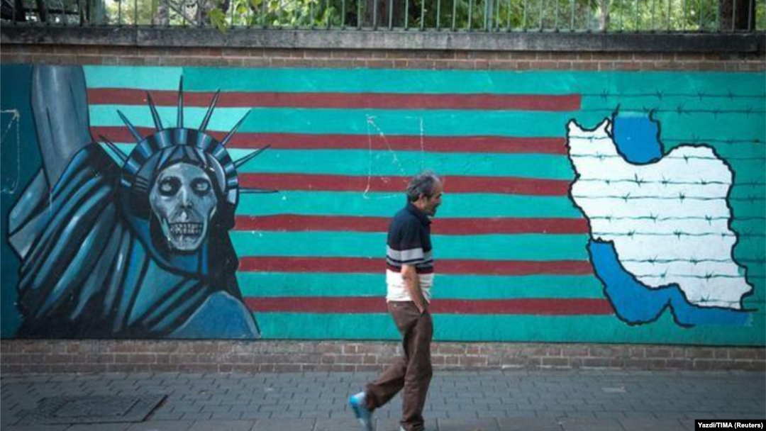 Čovjek prolazi protiv anti-Američkog murala u Teheranu.