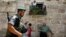 Israeli border police officer walks past Palestinians in Jerusalem's Old City before a parade marking Jerusalem Day, May 8, 2013.
