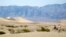 Sara Calcinaro (L) and Marco Rizzelli of Italy walk in the Mesquite Dunes as high temperatures approach record levels in Death Valley National Park, California Jun. 29, 2013.