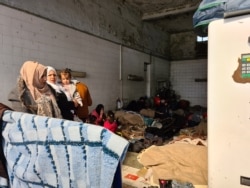 FILE - Refugees take shelter in a gas station in the Turkish country side, saying they want to cross the closed Greek border and do not want to be taken to Istanbul, were they could be homeless and potentially exposed to coronavirus, March 18, 2020.