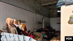 Refugees take shelter in a gas station in Turkey saying they want to cross the closed Greek border and do not want to be taken to Istanbul, were they could be homeless and potentially exposed to coronavirus on March 18, 2020. (Heather Murdock/VOA)