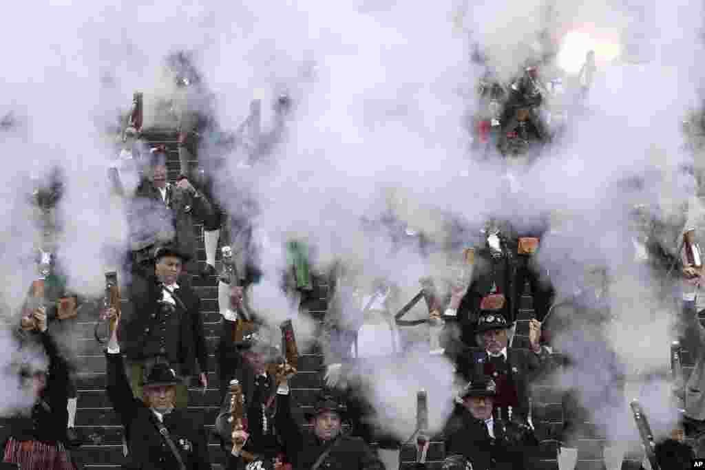 Bavarian riflemen and women in traditional costumes fire their muzzle loaders in front of the &#39;Bavaria&#39; statue on the last day of the 184th Oktoberfest beer festival in Munich, Germany.