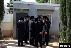 الڑا آرتھوڈوکس یہودی نوجوان لازمی فرجی بھرتی کے مرکز کے باہر استثنیٰ حاصل کرنے کے لیے اکھٹے ہیں۔ 28 مارچ 2024