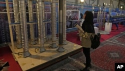 FILE -A student looks at Iran's domestically built centrifuges in an exhibition of the country's nuclear achievements, in Tehran, Feb. 8, 2023.