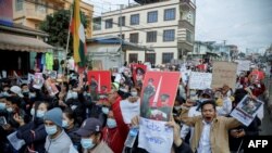 People take part in a demonstration against the February 1 military coup, along a street in the town of Muse in Shan state, near the China-Myanmar border on February 8, 2021. (Photo by STR / AFP)