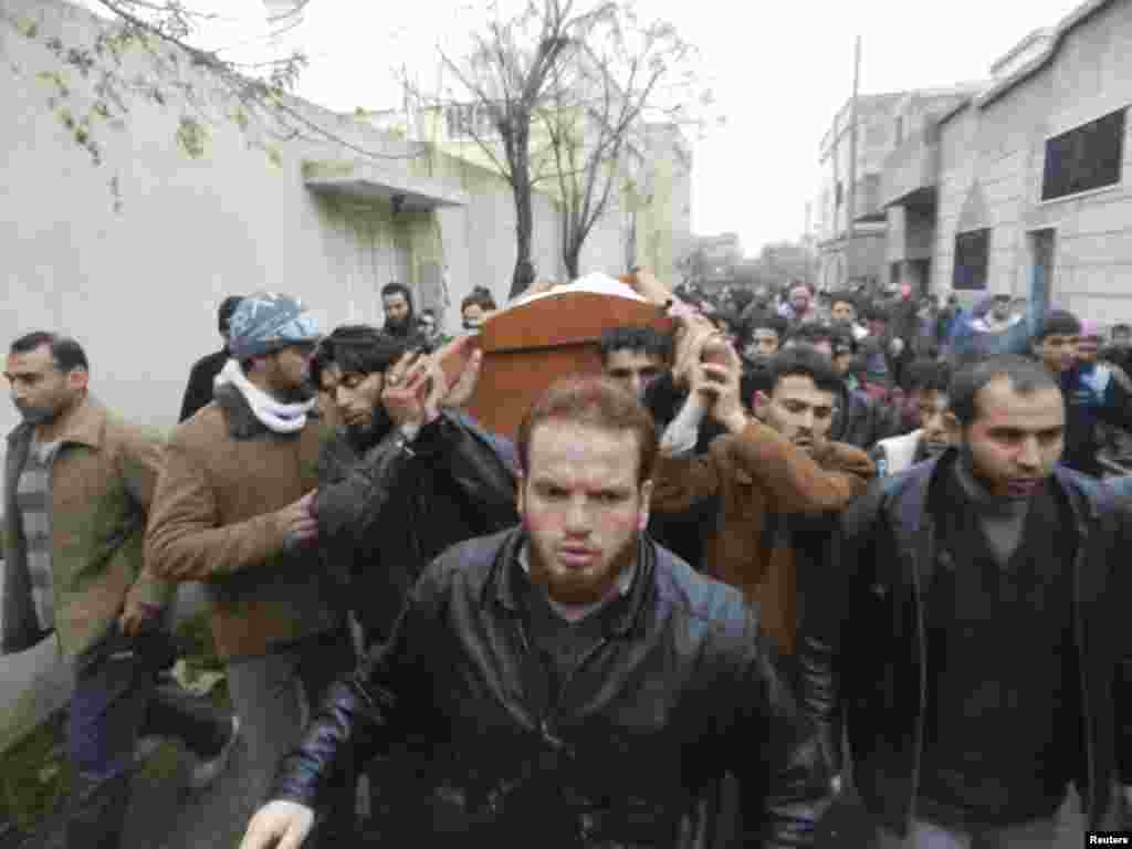 Residents and Free Syrian Army fighters carry the body of Muhammad Abed Al Muati Al-Salah, whom activists say was killed after a Syrian Air Force fighter jet loyal to Syria's President Bashar al-Assad fired missiles, in Houla, near Homs, December 23.