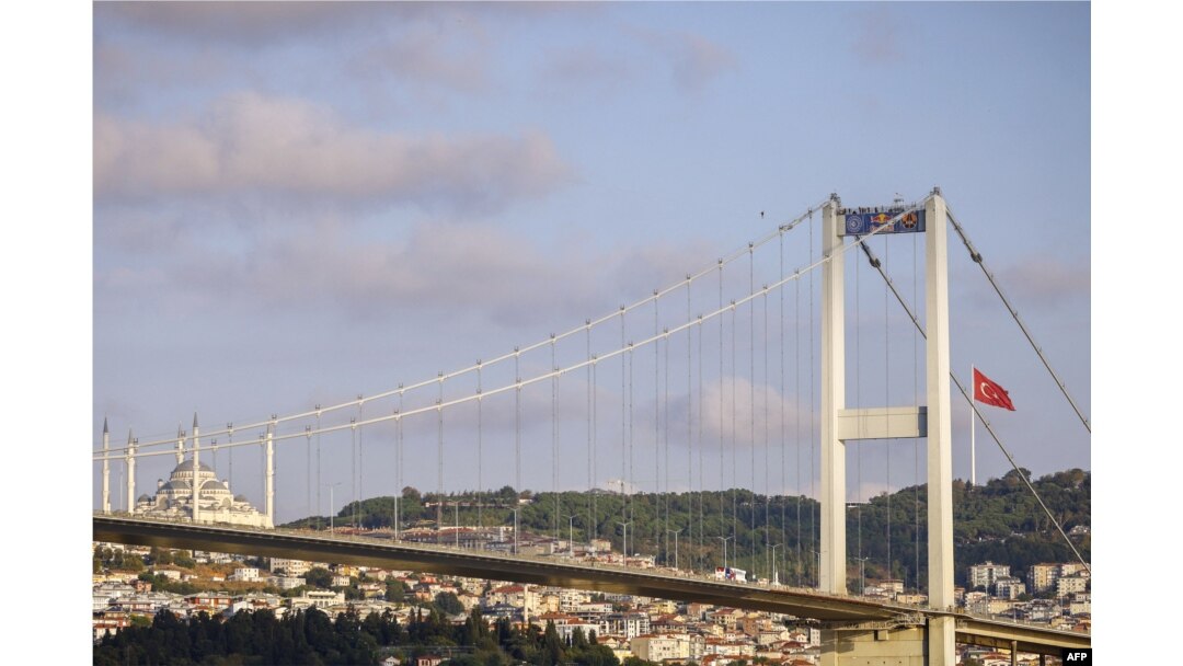 Atlet Estonia Jaan Roose berjalan di atas tali di atas Jembatan Martir (Bosphorus) di Istanbul, 15 September 2024. (KEMAL ASLAN / AFP)