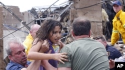 Seorang anak ditarik dari reruntuhan Sekolah Dasar Plaza Towers di Moore, Oklahoma (20/5) menyusul tornado yang menghantam negara bagian itu. (AP/Sue Ogrocki)