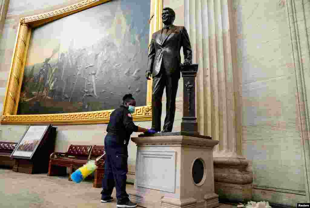Un trabajador limpia una estatua del ex presidente Ronald Reagan dentro de la Rotonda del Capitolio.