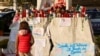 A child stands in front of candles, cards and other tributes to Pope Francis, outside Gemelli Hospital where the pope is admitted for treatment, in Rome, Italy, March 6, 2025.