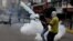 A demonstrator throws a tear gas canister during riots at a rally against Venezuelan president Nicolas Maduro's government in Caracas, Venezuela, June 7, 2017.