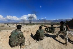 FILE- Afghan security forces take position during a gunbattle between Taliban and Afghan security forces in Laghman province, Afghanistan, March 1, 2017.