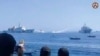 FILE - In this image taken from video provided by the Philippine coast guard, two Chinese ships aim their water cannons on a Philippine Bureau of Fisheries and Aquatic Resources vessel, center, as it approaches Scarborough Shoal in the disputed South China Sea on Dec. 9, 2023. 