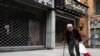 FILE - A homeless man walks past closed shops during a countrywide lockdown to combat the spread of the coronavirus disease in Beirut, Lebanon, April 3, 2020.