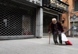 A homeless man walks past closed shops during a countrywide lockdown to combat the spread of the coronavirus disease (COVID-19) in Beirut, Lebanon April 3, 2020. (REUTERS/Mohamed Azakir)