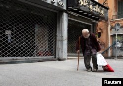 A homeless man walks past closed shops during a countrywide lockdown to combat the spread of the coronavirus disease (COVID-19) in Beirut, Lebanon April 3, 2020. (REUTERS/Mohamed Azakir)