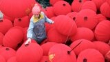 A worker walks among newly-made red lanterns ahead of the Spring Festival at a family workshop in Wenxian county, Henan province, China.