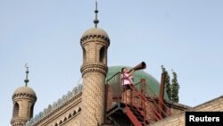 Seorang imam dari kelompok Muslim Uighur di Xinjiang, China, melakukan azan. (Foto: Dok)