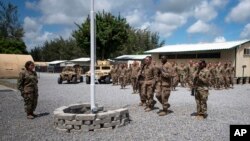 Para pilot dari Skuadron 475th mengikuti upacara bendera di Kamp Simba, yang digunakan sebagai tempat latihan tentara AS dan Kenya di Manda Bay, Kenya, 26 Agustus 2019. (Foto: AP)