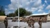 En esta foto del 26 de agosto de 2019, publicada por la Fuerza Aérea de EE.UU., aviadores del 475 ° Escuadrón de la Base Aérea Expedicionaria realizan una ceremonia de izado de banderas, en Camp Simba, Manda Bay, Kenia.