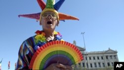 Un activista a favor de los matrimonios entre personas del mismo sexo celebra la decisión de la Cámara de Diputados frente al edificio del parlamento en Montevideo.