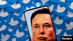 FILE PHOTO: Illustration shows Elon Musk image on smartphone and printed Twitter logos