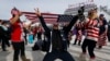 FILE - Fans celebrate with a U.S. flag after Jamie Anderson of the United States won the women's snowboard slopestyle final at the 2014 Winter Olympics, Feb. 9, 2014