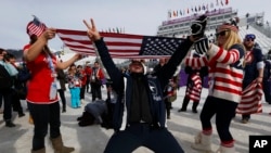 FILE - Fans celebrate with a U.S. flag after Jamie Anderson of the United States won the women's snowboard slopestyle final at the 2014 Winter Olympics, Feb. 9, 2014