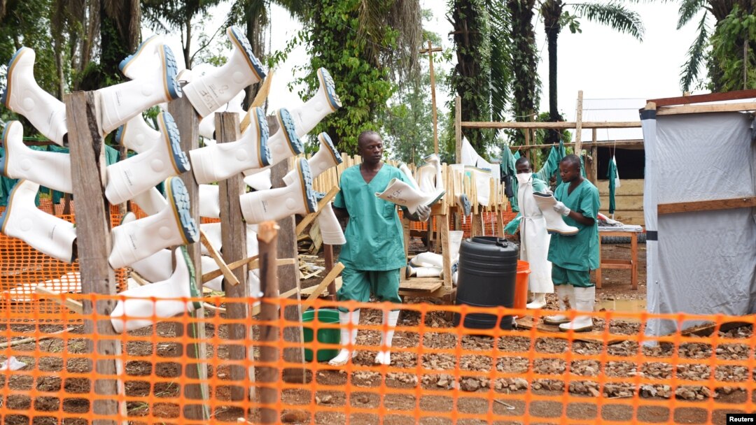 Congolese health workers clean gumboots as they prepare the Ebola treatment center in the village of Mangina in North Kivu province of the Democratic Republic of Congo, Aug. 18, 2018.