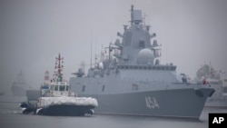 Sebuah kapal tunda mengawal kapal fregat Rusia Laksamana Gorshkov saat bersiap berlabuh di pelabuhan Qingdao di Provinsi Shandong, China timur (foto: dok). China dan Rusia memulai latihan angkatan laut bersama. 