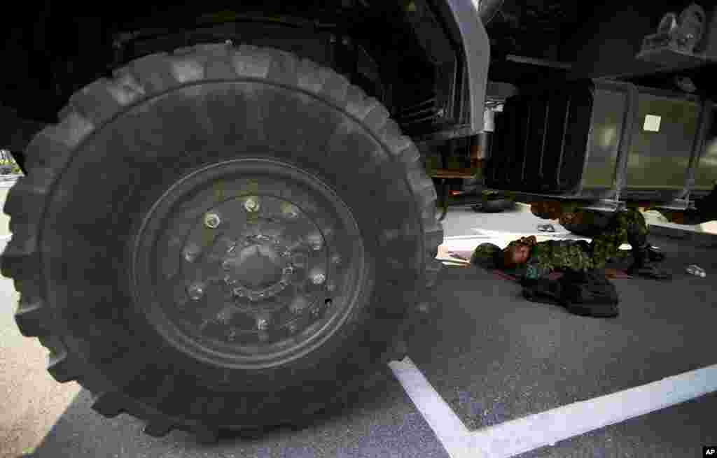 A Thai soldier lies under a truck to take a nap at National Anti-Corruption Commission office in Bangkok, Feb. 27, 2014.&nbsp;