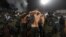 Police escort the soccer fans injured during the fights at a match between Red Star and Partizan in Belgrade, Dec. 13, 2017.