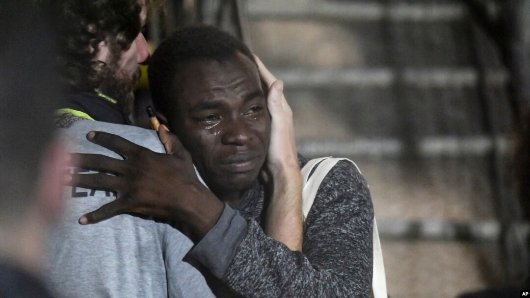 In this photo taken on Tuesday, Aug. 20, 2019 a man cries as he hugs a crew member after disembarking from the Open Arms rescue ship on the Sicilian island of Lampedusa, southern Italy. An Italian prosecutor ordered the seizure of a rescue ship and…