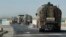 FILE - A convoy of oil trucks passes a Kurdish police (Assayesh) checkpoint, as they transport fuel produced in Kurdish-held areas in the east to other areas controlled by the same U.S.-backed group to the west, on a highway in Hassakeh province, Syria, April 4, 2018.