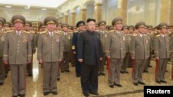 မြောက်ကိုရီးယားခေါင်းဆောင် ကင်ဂျုံအန်း (လယ်) နဲ့ တပ်မတော်အရာရှိကြီးတွေ မြောက်ကိုရီးယားတည်ထောင်သူ ကင်အီဆွန်းနဲ့ ဖခင်ဖြစ်သူ ကင်ဂျုံအီးလ်တို့အား ဂါရဝပြုနေစဉ်။ (ဇန်နဝါရီ ၁၊ ၂၀၁၅)