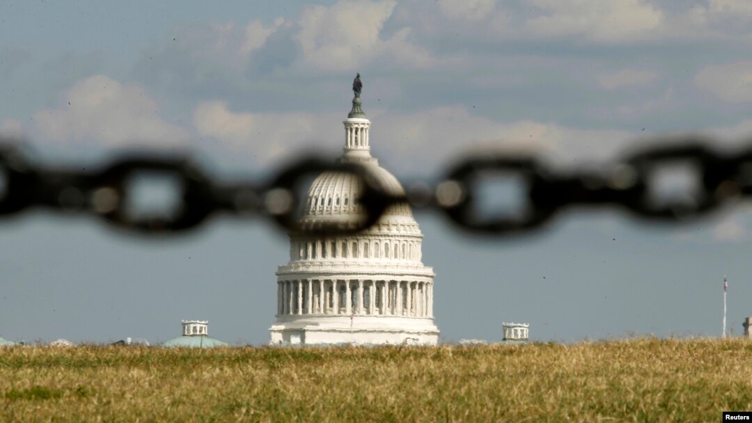 El Capitolio fotografiado a través de una cadena, simbolizando el cierre del gobierno.