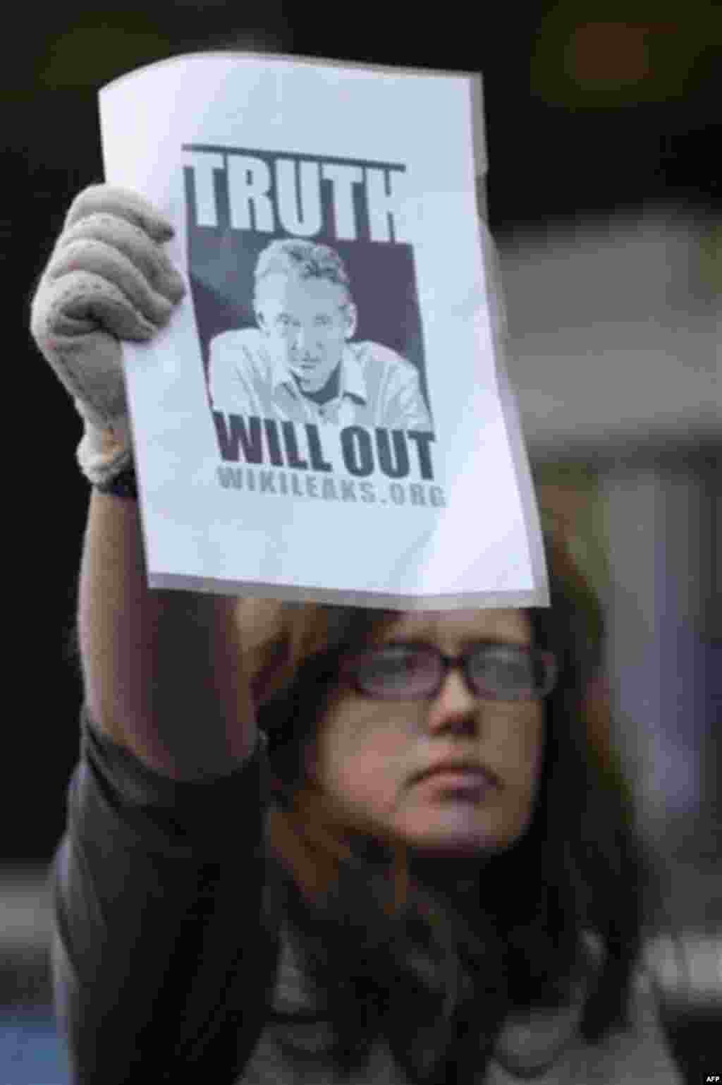 A supporter of whistle-blowing website Wikileaks founder Julian Assange holds up a placard outside the City of Westminster Magistrates Court in London where Julian Assange is in court, Tuesday, Dec. 7, 2010. Julian Assange was jailed Tuesday after the 