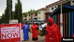 Seseorang melakukan kampanye "#Bring Back Our Girls" dan meneriakkan slogan selama rally dan menuntut pembebasan murid perempuan yang diculik pada bulan April oleh militan Boko Haram, di Abuja, 17 Oktober 2014. 