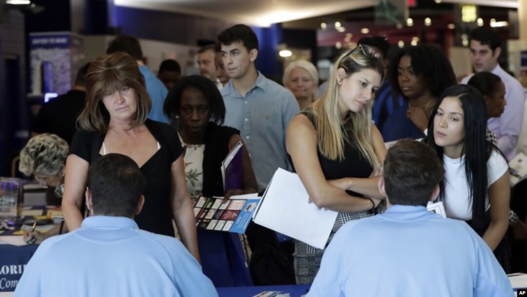 En esta foto de archivo del 21 de junio de 2018, solicitantes de empleo conversan con representantes de Aldi en una feria de trabajo organizada por Job News South Florida, en Sunrise, Florida. 