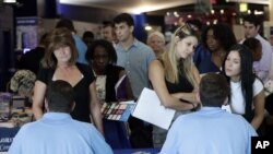 En esta foto de archivo del 21 de junio de 2018, solicitantes de empleo conversan con representantes de Aldi en una feria de trabajo organizada por Job News South Florida, en Sunrise, Florida. 