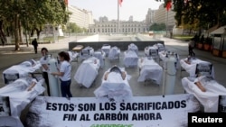 Demonstrators take part in a protest against climate change called by Greenpeace activists ahead of the 2019 United Nations Climate Change Conference, in Santiago, Chile, Oct. 17, 2019. The placard reads: "These are the sacrificed, end to the coal now."