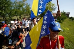 FILE - Participants of the "March for Peace," carrying Bosnian flags, walk near the village of Nezuk, some 150 kilometers northeast of Sarajevo, July 8, 2015.