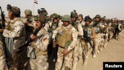 Iraqi security forces wait for vehicles traveling to Mosul to fight against militants of Islamic State at an Iraqi army base in Camp Taji in Baghdad, Feb. 21, 2016.