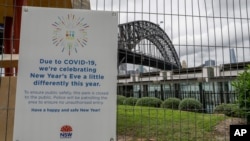 A signs adorns a security fence near the harbour foreshore ahead of New Years Eve in Sydney, Australia, Thursday, Dec. 31, 2020. One million people would usually crowd the Sydney Harbor to watch the annual fireworks that center on the Sydney Harbor…