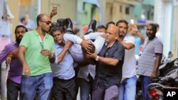 Maldivian lawmaker Faisal Naseem, hurt in clashes with police, is rushed to a hospital in Male, Maldives, July 24, 2017. The Maldivian opposition says the military locked down parliament on orders of the president to prevent a vote to impeach the parliamentary speaker. An Amnesty International official says a resumption of executions in the country is a "ploy" by the government to draw attention away from its problems.