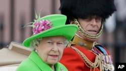  Ratu Elizabeth II dan Pangeran Philip dalam sebuah parade di Istana Buckingham, London (11/6). (AP/Tim Ireland)