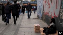 A young girl sells tissues to passersby on the Karakoy sea promenade in Istanbul, Turkey, Dec. 7, 2024.