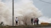 La gente se para frente a las olas que rompen contra la costa mientras el huracán Beryl avanza hacia el sur de la isla, en Santo Domingo, República Dominicana, el 2 de julio de 2024.