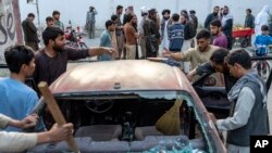 Warga membersihkan mobil yang rusak akibat ledakan, di Kabul, Afghanistan, Rabu, 21 September 2022. Taliban mengatakan sedikitnya tiga orang tewas dan 13 lainnya luka-luka dalam ledakan itu.